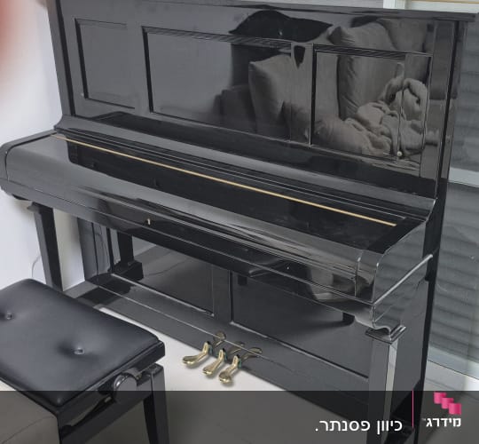 פסנתר שחור עם כיסא ליד חלון